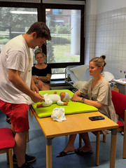 Teilnehmende der Mentorenausbildung üben im Skills Lab der Albertinen Akademie die Anleitung zur Säuglingspflege mit einer Babypuppe.