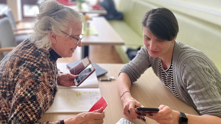 Foto einer Seniorin mit ihrer Mentorin bei Digitalschulung im Projekt Quartiersentwicklung für Ältere im Zentrum für Geriatrie und Gerontologie des Albertinen Hauses in Hamburg