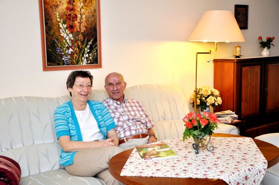 Ein Mann und eine Frau sitzen gemeinsam auf einem Sofa in einer Wohnung der Albertinen Haus Service-Wohnanlage, Seite Wohnungen, Alvertinen Haus