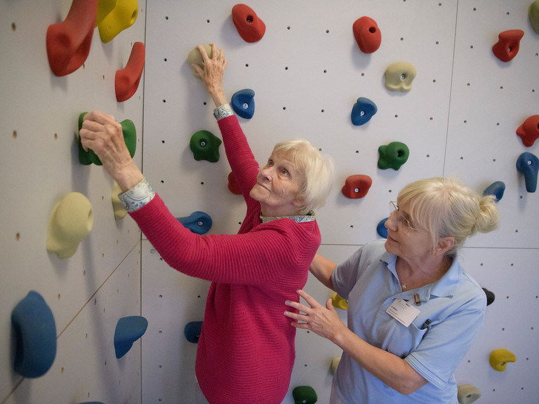 Bewohnerin einer Pflegeeinrichtung trainiert mit therapeutischer Unterstützung ihre Mobilität im Rahmen des Pilotprojekts SGB Reha im Albertinen Haus Hamburg.