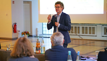 Ein Redner spricht bei seinem Vortrag mit einem Mikrofon in der Hand vor dem Publikum beim Einführungssymposium „Die Zukunft ist alt!“ von Priv.-Doz. Dr. Gödel, Chefarzt der Klinik für Geriatrie im Albertinen Zentrum für Altersmedizin im Albertinen Krankenhaus in Hamburg. Ein Redner spricht bei seinem Vortrag mit einem Mikrofon in der Hand vor dem Publikum beim Einführungssymposium „Die Zukunft ist alt!“ von Priv.-Doz. Dr. Gödel, Chefarzt der Klinik für Geriatrie im Albertinen Zentrum für Altersmedizin im Albertinen Krankenhaus in Hamburg.