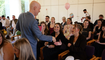 Staatsrat Tim Angerer gratuliert den frisch examinierten Pflegefachpersonen bei der Abschlussfeier.