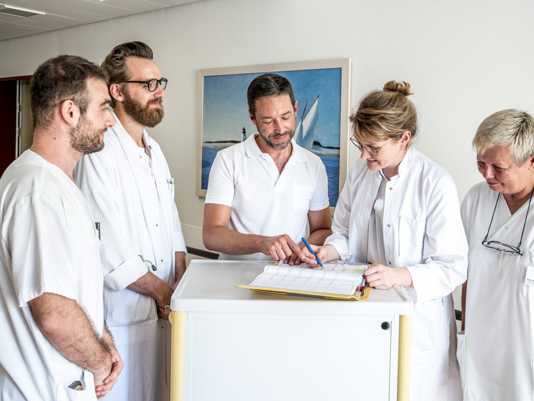 Ärzte und Pflegekräfte schauen auf eine Akte - stationäre Klinik - Albertinen Haus in Hamburg
